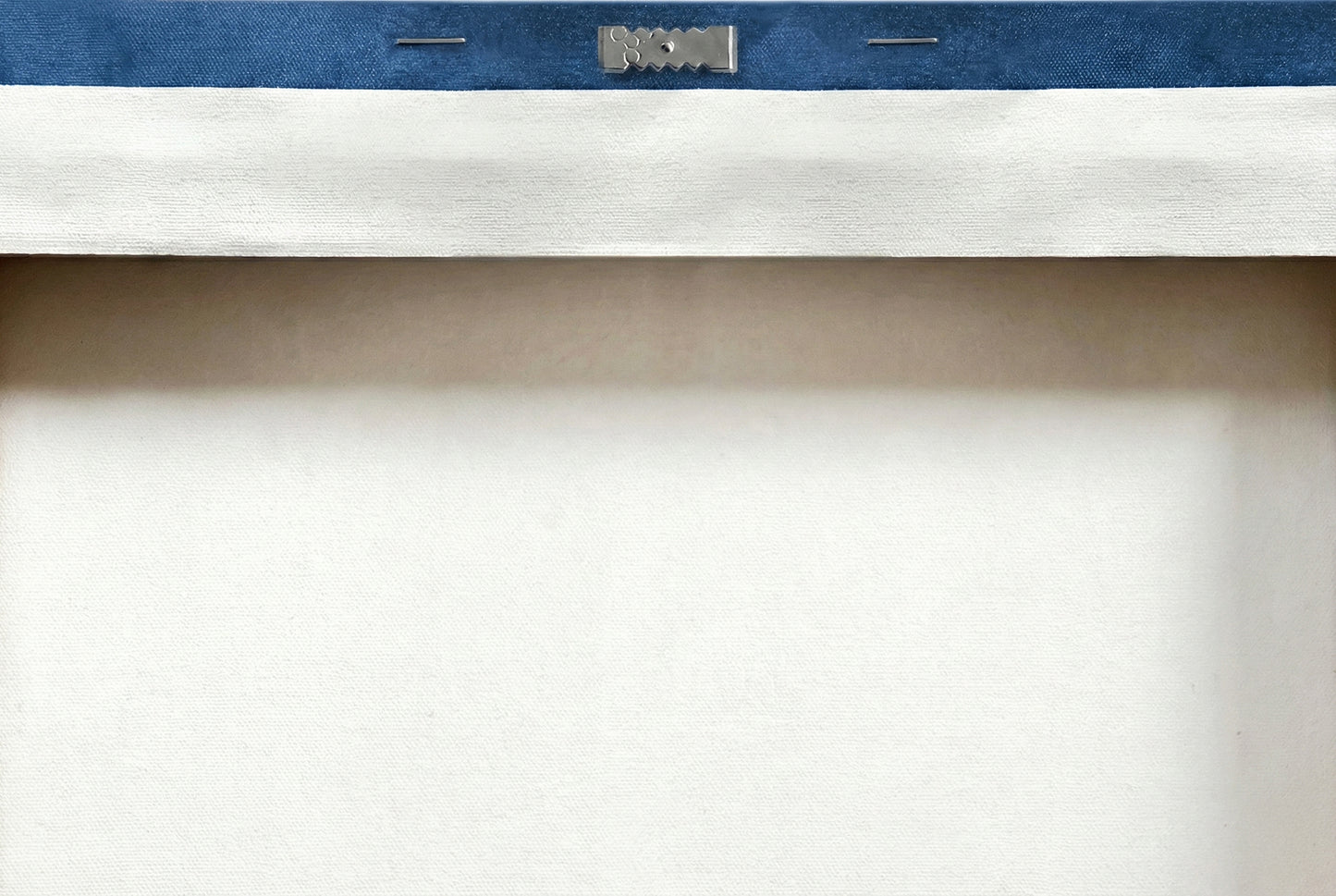 Close up of sawtooth hanger hardware installed on back of canvas for easy leveling