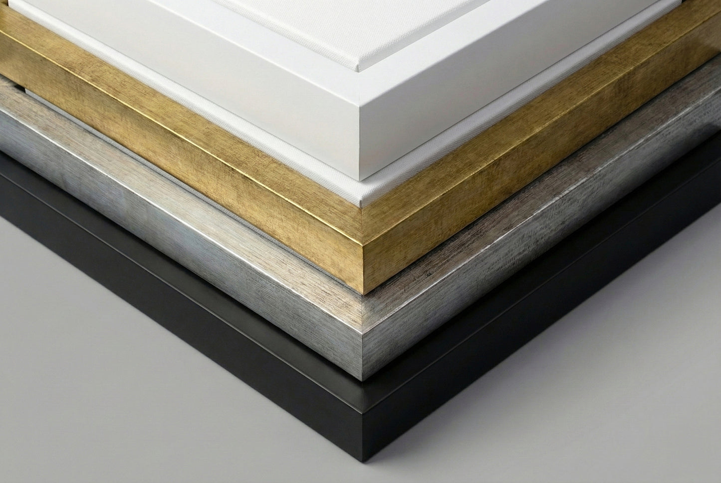 Close up comparison of floating frame color options showing black white gold and silver finishes for canvas art